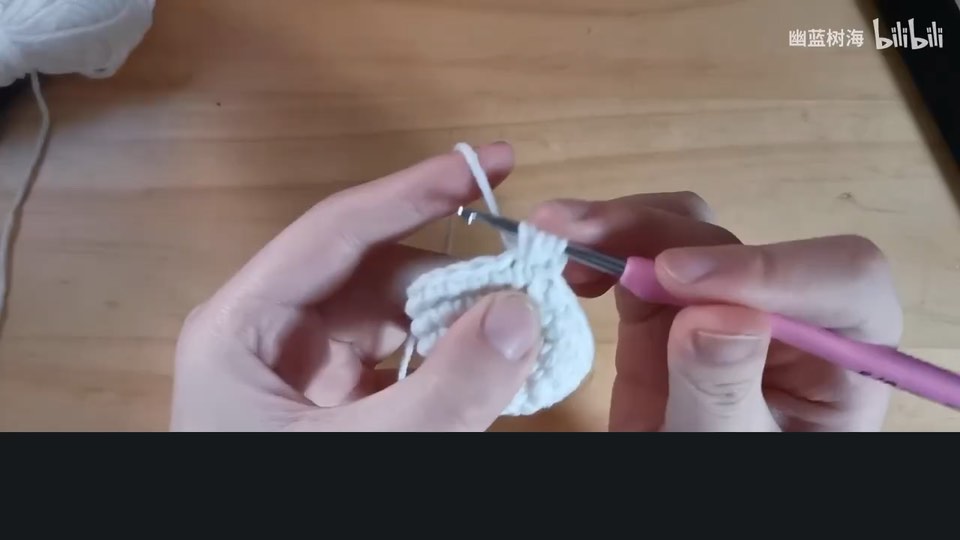Holding the yarn and crochet hook — tutorial video frame